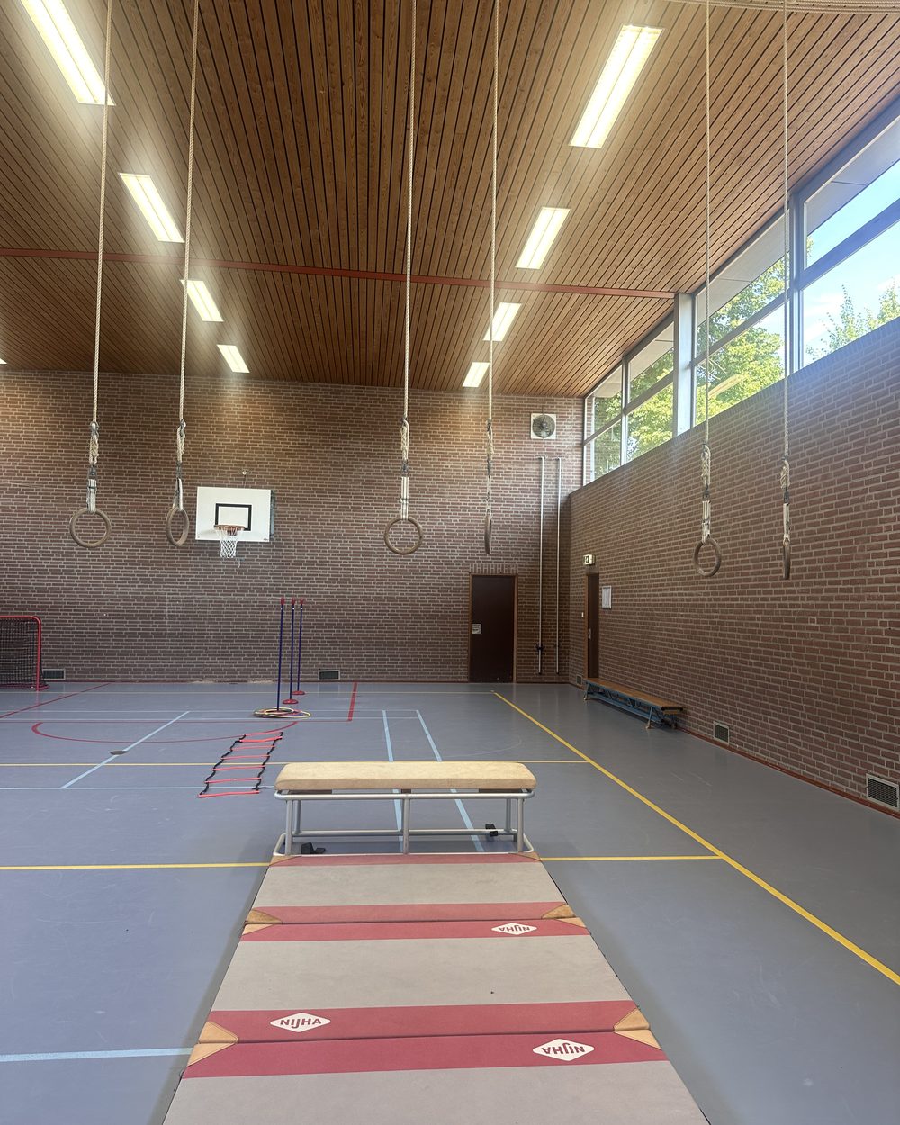 Oefenparcours met ringen en mat in de beweegruimte — stap voor stap oefenen